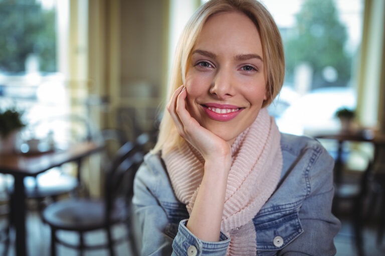 smiling woman sitting cafa - „Wspieramy każdego w odkrywaniu i rozwijaniu swojego potencjału, by żyć pełnią życia”