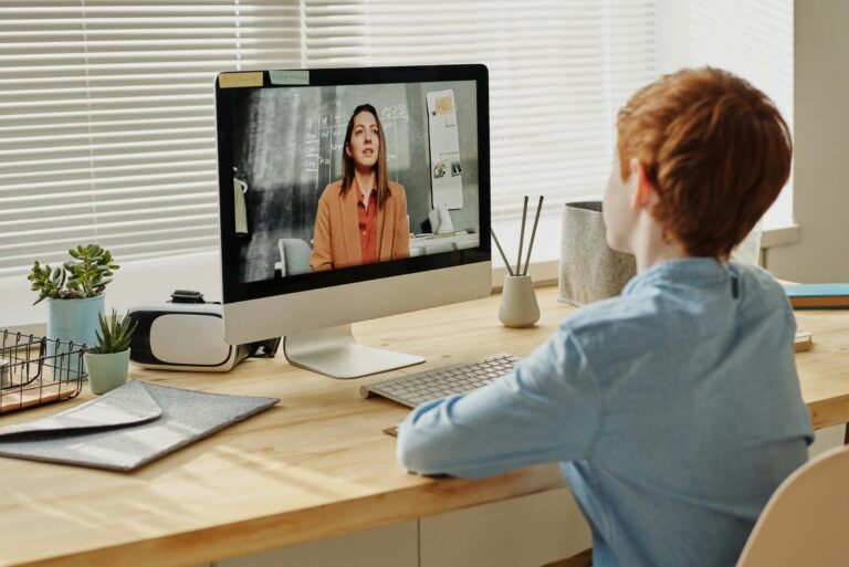 Child attending an online class at home via computer, enhancing remote education.