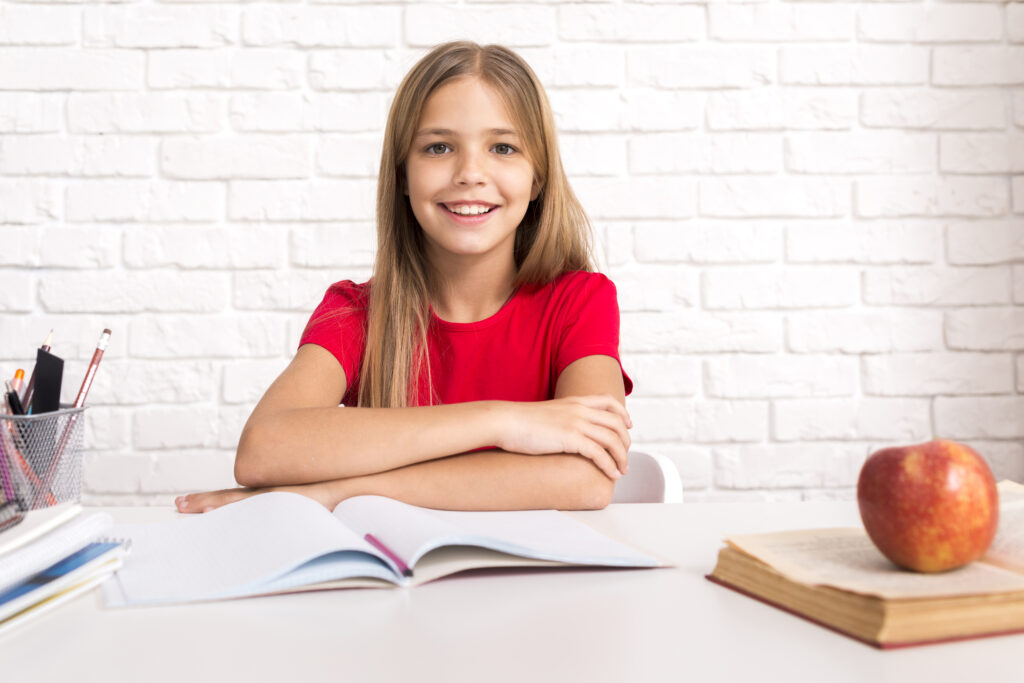 casual schoolgirl sitting desk - „Wspieramy każdego w odkrywaniu i rozwijaniu swojego potencjału, by żyć pełnią życia”