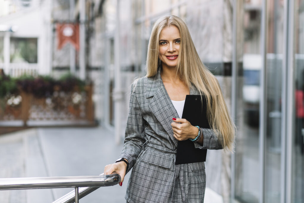 stylish businesswoman with clipboard city - „Wspieramy każdego w odkrywaniu i rozwijaniu swojego potencjału, by żyć pełnią życia”